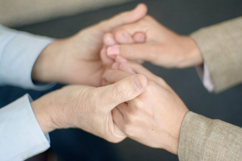 Dedicated Ongoing Support Two people holding hands to provide ongoing patient care and support